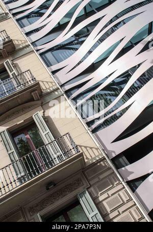 Modernes avantgardistisches Gebäude gegenüber Gaudis La Pedrera, möglicherweise luxuriöse Apartments, Suites Avenue Hotel. Es ist das Alte im Vergleich zum Neuen. Stockfoto