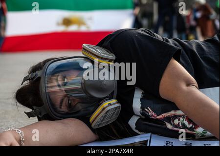 Madrid, Spanien. 11. März 2023. Eine Frau, die eine Gasmaske auf dem Boden trägt, wird während eines Protests gesehen, bei dem die iranische Gemeinschaft in Madrid gegen die Hunderten von jungen Mädchen demonstriert, die im Iran vergiftet wurden, in einem mutmaßlichen Versuch, Schulen seit dem vergangenen November zu schließen. Kredit: Marcos del Mazo/Alamy Live News Stockfoto