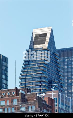 NYC Midtown: 100 United Nations Plaza hat eine keilförmige Krone, die von Balkonen umgeben ist, die sich fast bis zur Straßenebene hinunter bewegen. Stockfoto