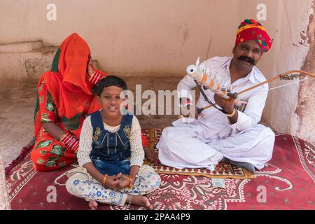 Jodhpur, Rajasthan, Indien - 18. Oktober 2019: Rajasthani männlicher Volkskünstler mit Familie in traditionellen Kleidern, der Sarengi im Fort Meharngarh spielt. Stockfoto