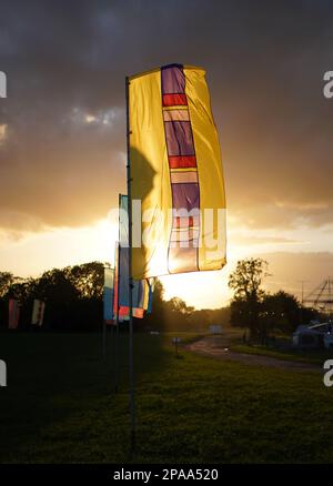 Farbenfrohe Banner auf der Worthy Farm, Pilton, dem Veranstaltungsort des Glastonbury Festivals, am frühen Abend bei Sonnenuntergang. Stockfoto