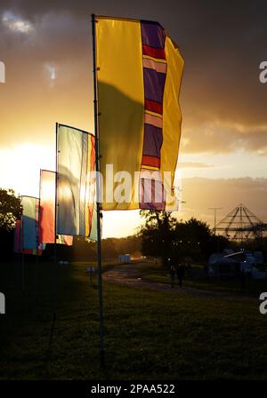 Farbenfrohe Banner auf der Worthy Farm, Pilton, dem Veranstaltungsort des Glastonbury Festivals, am frühen Abend bei Sonnenuntergang. Stockfoto