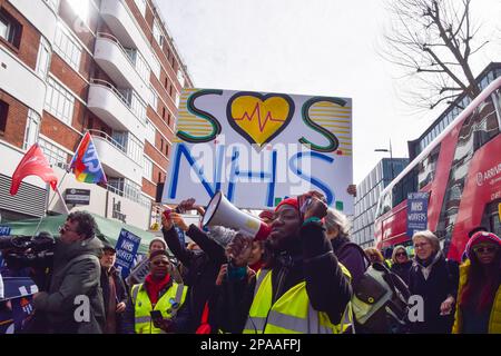 London, Großbritannien. 11. März 2023. Während der Demonstration in der Tottenham Court Road singt ein Demonstrant Slogans durch ein Megafon. Tausende von Menschen marschierten durch das Zentrum von London, um den NHS (National Health Service) und NHS-Arbeiter zu unterstützen und gegen die Privatisierung des NHS zu protestieren. Kredit: SOPA Images Limited/Alamy Live News Stockfoto