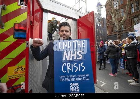 London, Großbritannien. 11. März 2023. Riccardo la Torre, nationaler Offizier der Feuerwehr, hält ein Plakat, um NHS-Arbeiter während der Demonstration zu unterstützen. SOS NHS-Kampagnengruppe und andere Gewerkschaften organisierten einen marsch vom University College London Hospital nach Downing Street, um Soforthilfe für den National Health Service (NHS) von der britischen Regierung zu fordern, um Dienstleistungen und Personal zu unterstützen und nicht, um den Gesundheitssektor vor dem Frühling des Kanzlers zu privatisieren Haushaltsplan vom 15. März 2023. Kredit: SOPA Images Limited/Alamy Live News Stockfoto