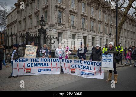 London, Großbritannien. 11. März 2023. NHS-Mitarbeiter, darunter Ärzte und Krankenschwestern und ihre Unterstützer, werden während der Demonstration mit einem Banner vor der Downing Street gesehen. SOS NHS-Kampagnengruppe und andere Gewerkschaften organisierten einen marsch vom University College London Hospital nach Downing Street, um Soforthilfe für den National Health Service (NHS) von der britischen Regierung zu fordern, um Dienstleistungen und Personal zu unterstützen und nicht, um den Gesundheitssektor vor dem Frühling des Kanzlers zu privatisieren Haushaltsplan vom 15. März 2023. Kredit: SOPA Images Limited/Alamy Live News Stockfoto