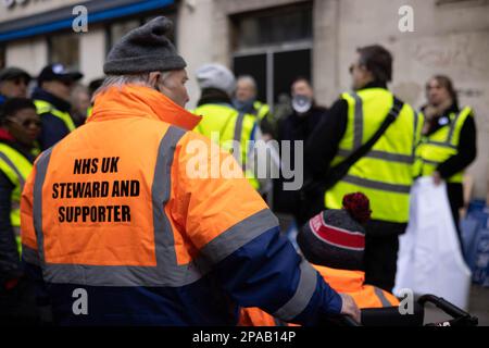 London, Großbritannien. 11. März 2023. Ein Steward wird gesehen, wie er vor dem marsch vor dem University College London Hospital in London an der Besprechung teilnimmt. SOS NHS-Kampagnengruppe und andere Gewerkschaften organisierten einen marsch vom University College London Hospital nach Downing Street, um Soforthilfe für den National Health Service (NHS) von der britischen Regierung zu fordern, um Dienstleistungen und Personal zu unterstützen und nicht, um den Gesundheitssektor vor dem Frühling des Kanzlers zu privatisieren Haushaltsplan vom 15. März 2023. Kredit: SOPA Images Limited/Alamy Live News Stockfoto