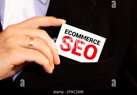 Business Concept. Text ECOMMERCE SEO Schreiben auf Notizbuch mit offenem Stift, zerrissenem Papier und Taschenrechner auf blauem Hintergrund. Stockfoto