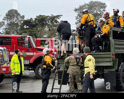 Monterey County, Vereinigte Staaten von Amerika. 11. März 2023. Erste-Hilfe-Helfer helfen Bewohnern in einem Hochwasserfahrzeug der National Guard sicher auf dem Trockenen, da Teile von Kalifornien nach dem zehnten atmosphärischen Flussereignis in der Nähe des Pajaro River, 11. März 2023 in Monterey County, Kalifornien, unter schweren Überschwemmungen leiden. Kredit: California National Guard/USA Army Photo/Alamy Live News Stockfoto