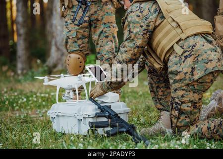 Modern Warfare Soldiers Squad verwenden Drohne für Scouting und Überwachung während der militärischen Operation im Wald. Stockfoto