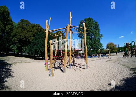 Klettergerüst aus Holz auf einem Spielplatz mit sandigem Boden in einem kölner Park an einem sonnigen Tag Stockfoto