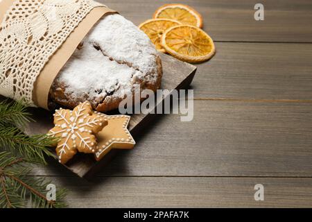 Traditionelle Weihnachtsstollen und Kekse auf Holztisch, Nahaufnahme. Platz für Text Stockfoto