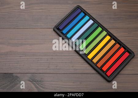 Farbenfrohe Pastelltöne im Tablett auf einem Holztisch, Platz für Text. Zeichenmaterialien Stockfoto
