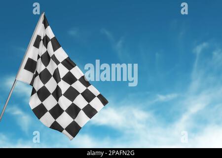 Die Zielflagge mit Karomuster vor blauem Himmel. Platz für Text Stockfoto