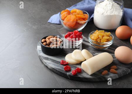 Marzipan und andere Zutaten für hausgemachtes Stollen auf grauem Tisch. Traditionelles deutsches Weihnachtsbrot backen Stockfoto