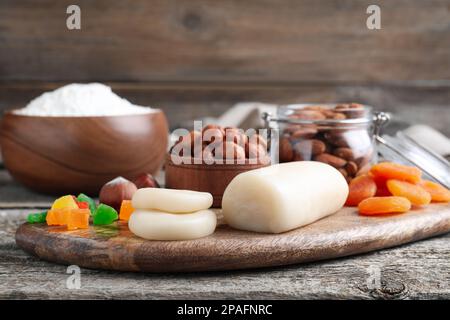 Marzipan und andere Zutaten für hausgemachtes Stollen auf einem Holztisch. Traditionelles deutsches Weihnachtsbrot backen Stockfoto