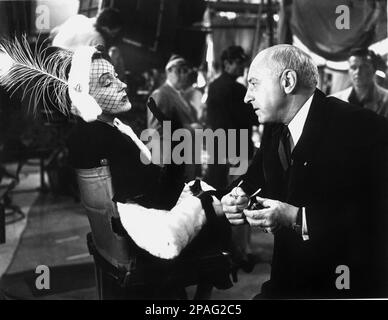 1951 : die Filmdarstellerin GLORIA SWANSON ( Chicago 1898 - New York 1983 ) als Norma Desmond in SUNSET BOULEVARD ( Viale del Tramonto ) von Billy Wilder , Kostüm von Edith HEAD , Paramount Publicity noch immer . Auf diesem Foto mit Filmregisseur CECIL B. DE MILLE - FILM - KINO - attrice cinematografica - VAMP - DIVA - DIVINA - GÖTTLICH - Hollywood on Hollywood - Pelz - lange Handschuhe - Guanti Lunghi - Hut - cappello - Veletta - verschleiert - Piuma di pavone - Feder ---- ARCHIVIO GBB Stockfoto