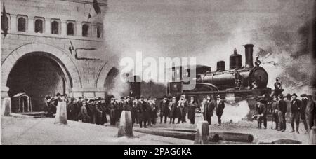 1906 , 25 . januar , TRAFORO DEL SEMPIONE , ITALIEN : der erste Zug, der durch den 19 km langen Tunnel von Briga ( Briga ) nach Iselle ( Italien) fährt . Der Simplon-Tunnel ist ein alpiner Eisenbahntunnel, der die Schweizer Stadt Brig mit Domodossola in Italien verbindet, obwohl seine relativ gerade Bahn nicht unter dem Simplon-Pass verläuft. Es besteht aus zwei einspurigen Tunneln, die in einem Abstand von fast 20 Jahren gebaut wurden. Mehr als ein halbes Jahrhundert lang galt er als der längste Tunnel der Welt. Der Simplon-Tunnel wurde schließlich 1906 fertiggestellt. Der italienische König Victor Emmanuel III. Von Italien und der Pre Stockfoto