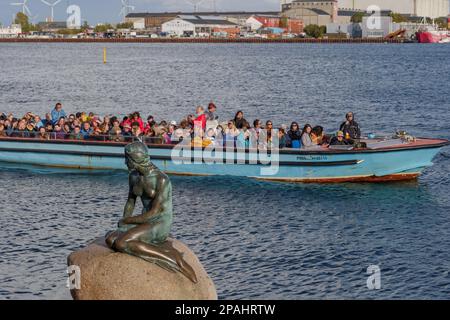 KOPENHAGEN, DÄNEMARK - OKTOBER 2019: Außenansicht der kleinen Meerjungfrau, Den Lille Havfrue und Hintergrund einer Bootstour mit vielen Touristen. Stockfoto