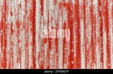 Rot lackierte verwitterte Wellplatten für einen Hintergrund, eine Struktur und eine Überlagerung. Stockfoto