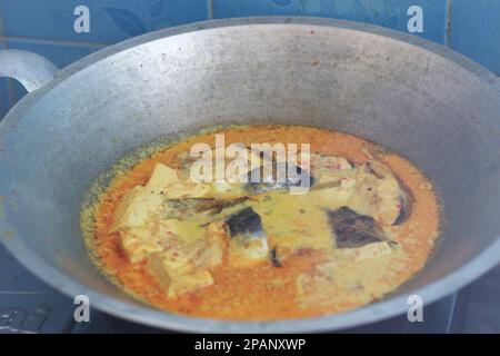 Foto von Thunfisch und weißem Tofu in gelber Gewürzsauce auf einer Pfanne. Fotokonzept für traditionelle indonesische Speisen. Stockfoto