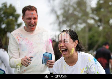 Fountain Valley, Usa. 11. März 2023. Die Teilnehmer des Holi Fest lachen, während sie an den Pulverwerfaktivitäten beim Festival of Colors teilnehmen. Die Teilnehmer trafen sich zum Holi Fest - Festival of Colors, um Holi, den offiziellen Übergang vom Winter zum Frühling, zu feiern. Sie veranstalteten Livemusik und lieferten bunten Pulverschnee für Freunde und Angehörige während der besonders freudigen Feier. Kredit: SOPA Images Limited/Alamy Live News Stockfoto