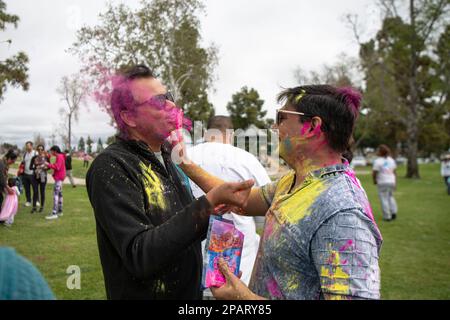 Fountain Valley, Usa. 11. März 2023. Holi Fest-Teilnehmer schlagen sich gegenseitig mit Pulver, während sie sich bei der Feier zusammentun. Die Teilnehmer trafen sich zum Holi Fest - Festival of Colors, um Holi, den offiziellen Übergang vom Winter zum Frühling, zu feiern. Sie veranstalteten Livemusik und lieferten bunten Pulverschnee für Freunde und Angehörige während der besonders freudigen Feier. Kredit: SOPA Images Limited/Alamy Live News Stockfoto