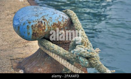 Schließmechanismus. Vergrößerte Darstellung eines großen blauen Metallhakens mit einem riesigen Seekabel zum Schleppen von Schiffen. Konzentrier dich auf den Haken Stockfoto