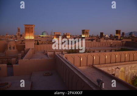 Panoramablick über die Stadt Yazd bei Sonnenuntergang mit Gebäuden und Windtürmen Stockfoto