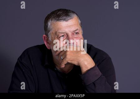 Nettes, unauffälliges Porträt eines bärtigen Ukrainers, der in der Dunkelheit meditiert Stockfoto