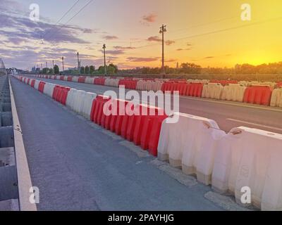 Straßensperren aus Kunststoff, gefüllt mit rotem und weißem Wasser. Rote und weiße Kunststoffzäune an der Straße der Autobahn, an der Ringstraße in der modernen Stadt. R Stockfoto