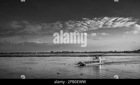 Eine überfüllte Flussfähre überquert den Mekong kurz nach Sonnenaufgang flussabwärts von Phnom Penh in Kambodscha. Stockfoto