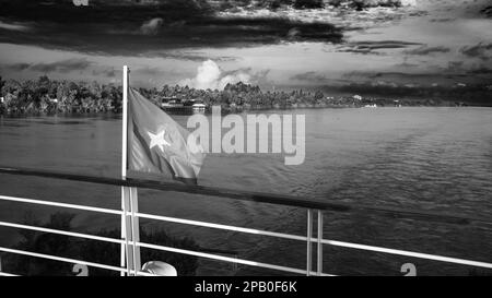 Das Heck des Victoria Mekong River Kreuzfahrtschiffs, das bei Sonnenaufgang in der Nähe von Phnom Penh auf dem Mekong in Kambodscha die vietnamesische Flagge fliegt. Stockfoto