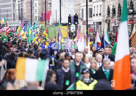 Teilnehmer und Menschenmassen während des St. Patrick's Day Festivals und der Parade im Zentrum von London. Foto: Sonntag, 12. März 2023. Stockfoto