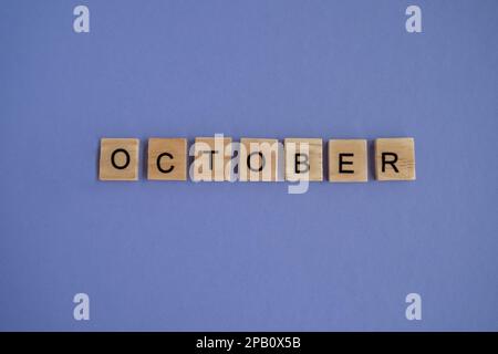 Der Name des Monats Oktober steht auf isolierten Holzwürfeln. Draufsicht auf Holzblöcke mit Buchstaben Stockfoto
