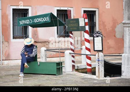 Venedig, Italien - 14. November 2022: Gondoliere, die auf den venezianischen Kanälen auf Touristen warten Stockfoto