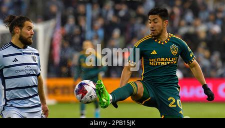 Kansas City, USA. 11. März 2023. Los Angeles Galaxy MEMO Rodríguez (20) legt den Ball fest, während der Mittelfeldspieler Graham Zusi (8) von Sporting Kansas City zusieht. Sporting KC war Gastgeber der LA Galaxy bei einem Major League-Fußballspiel am 11. März 2023 im Children's Mercy Park Stadium in Kansas City, KS, USA. Foto: Tim Vizer/Sipa USA Kredit: SIPA USA/Alamy Live News Stockfoto