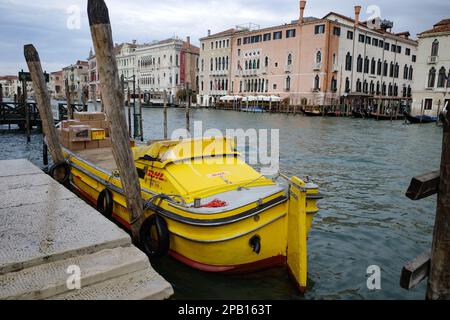 Venedig, Italien - 15. November 2022: Ein gelbes DHL-Boot, das Pakete auf dem Canale Grande von Venedig liefert Stockfoto