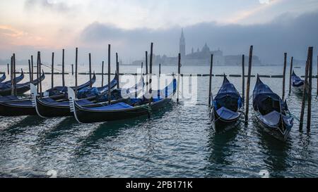 Venedig, Italien - 15. November 2022: Morgenblick auf Gondeln, den Canale Grande und den Glockenturm San Giorgio Stockfoto