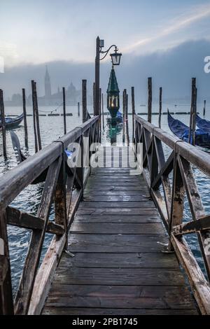 Venedig, Italien - 15. November 2022: Morgenblick auf Gondeln, den Canale Grande und den Glockenturm San Giorgio Stockfoto