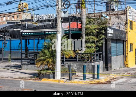 Zapopan, Jalisco Mexiko. 1. Januar 2023. Geschlossenes und leeres Autowaschanlagengeschäft an einer Ecke, Werbung vor blauem Himmel im Hintergrund, urbane Straße Stockfoto