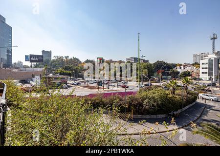 Guadalajara, Jalisco Mexiko. 28. Dezember 2022. Stadtbild mit Straßen, Geschäften, Autofahrern, Plakatwänden, Gebäuden und grünen Bäumen auf unscharfem Hintergrund Stockfoto