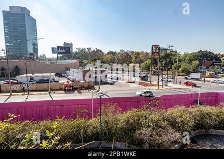 Guadalajara, Jalisco Mexiko. 28. Dezember 2022. Stadtbild mit Straßen, Geschäften, Autos, Plakatwänden, Gebäuden und grünen Bäumen auf unscharfem Hintergrund, Stockfoto