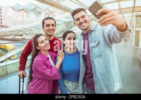Zwei Glückliche Paare, Die Mit Selfie Unterwegs Sind Und Spaß Am Flughafen Haben Stockfoto