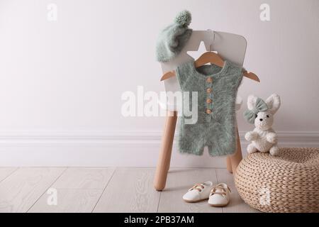 Set mit Kinderkleidung und -Schuhen im Zimmer. Platz für Text Stockfoto