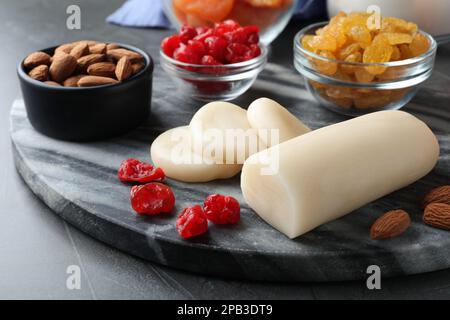 Marzipan und andere Zutaten für hausgemachtes Stollen auf grauem Tisch, Nahaufnahme. Traditionelles deutsches Weihnachtsbrot backen Stockfoto