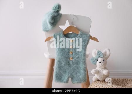 Set mit Kinderkleidung und -Schuhen im Zimmer Stockfoto