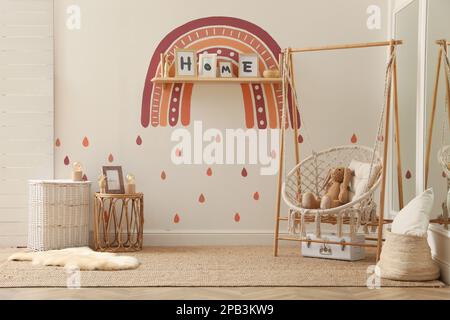 Innenausstattung des Kinderzimmers mit Regenbogengemälde an der Wand Stockfoto