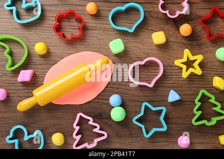 Spielteig in verschiedenen Farben mit Formen auf Holztisch, flach liegend Stockfoto