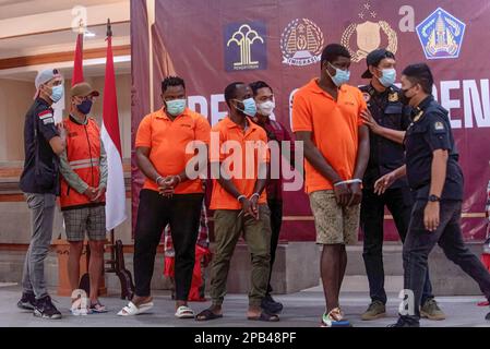 Denpasar, Indonesien. 12. März 2023. Bali-Einwanderungsbeamte eskortieren deportierte Ausländer nach einer Pressekonferenz. Bali hat vier nigerianische Staatsangehörige wegen Überschreitung der Aufenthaltsdauer und einen russischen Staatsangehörigen wegen Visummissbrauchs ausgewiesen. Die Provinz Bali, ein internationales Reiseziel, hat 2022 194 Ausländer abgeschoben, die meisten wegen Überschreitung der Aufenthaltsdauer und illegaler Beschäftigung. (Foto: Dicky Bisinglasi/SOPA Images/Sipa USA) Guthaben: SIPA USA/Alamy Live News Stockfoto