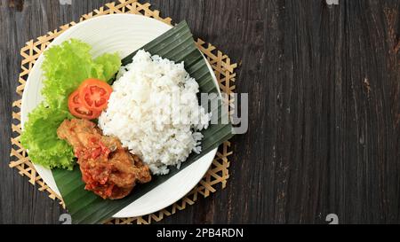 Draufsicht Ayam Penyet. Frittiertes Hähnchen mit Sambel oder Sambal, scharfe Chilisauce. Ayam Penyet oder Ayam Geprek ist traditionelle indonesische Küche Stockfoto